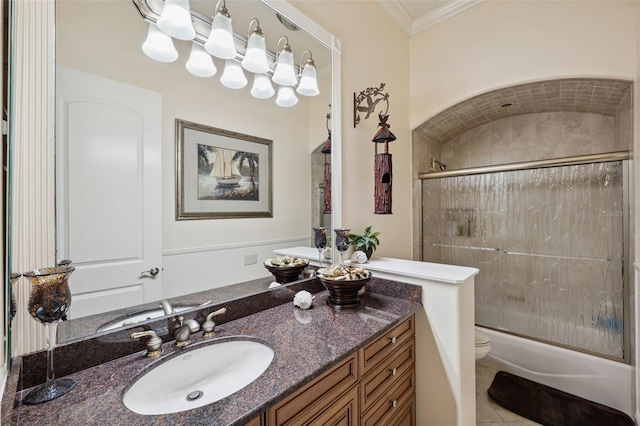 full bathroom featuring combined bath / shower with glass door, vanity, ornamental molding, tile patterned floors, and toilet