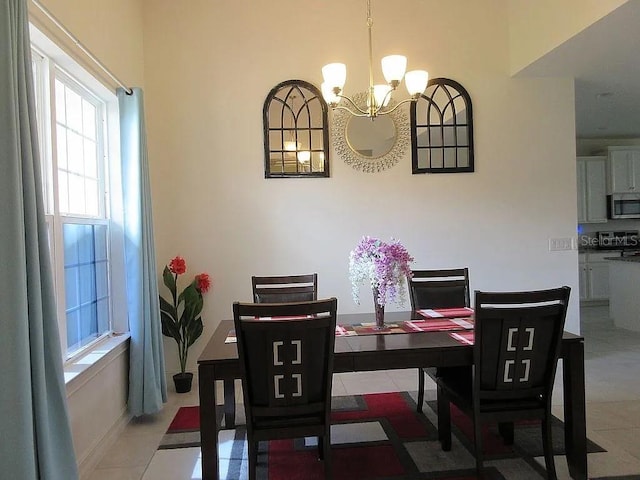 tiled dining room featuring a notable chandelier