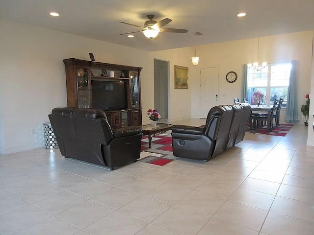 tiled living room featuring ceiling fan with notable chandelier