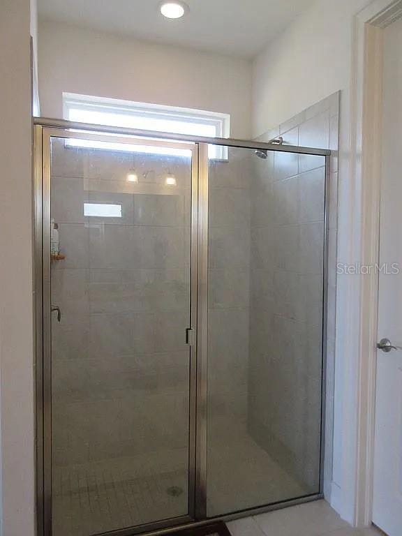 bathroom with a healthy amount of sunlight and a shower with shower door