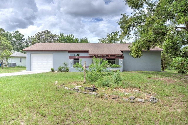 ranch-style house featuring a garage, a front lawn, and central air condition unit