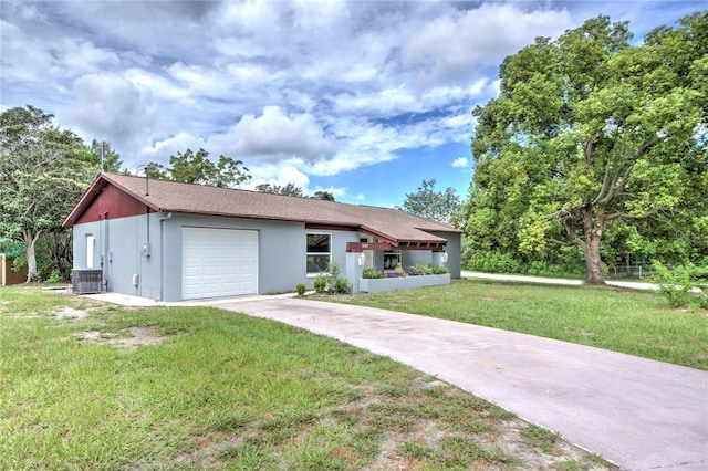 view of front of home with a garage, central AC unit, and a front lawn