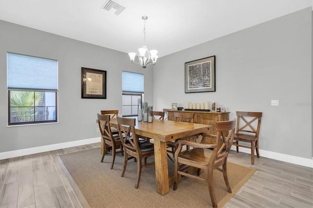 dining room with light hardwood / wood-style floors and a chandelier