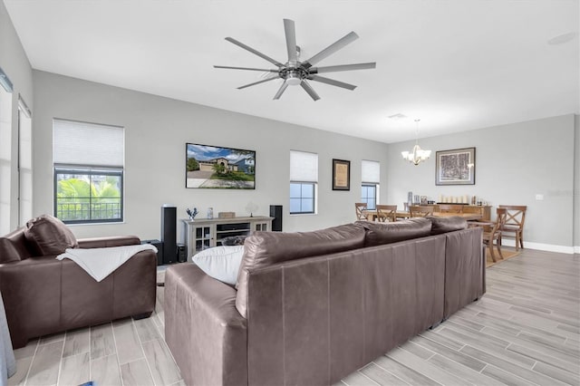 living room with ceiling fan with notable chandelier