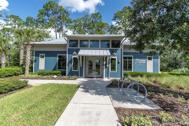 view of front facade with a front lawn and french doors