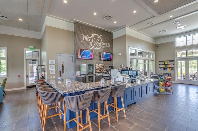 kitchen with a high ceiling, stone counters, and french doors