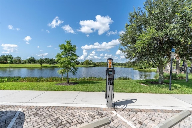 view of home's community with a water view and a lawn