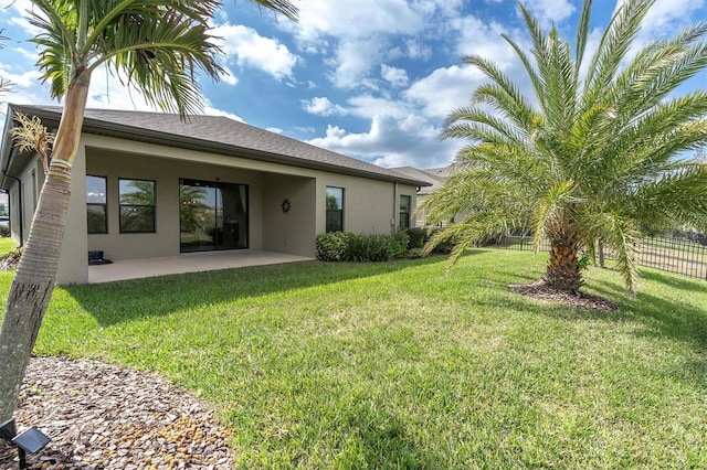 rear view of property with a patio and a lawn