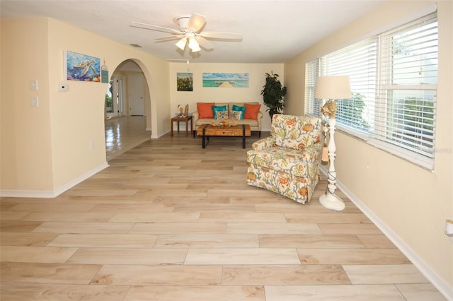 living area with ceiling fan and light hardwood / wood-style floors