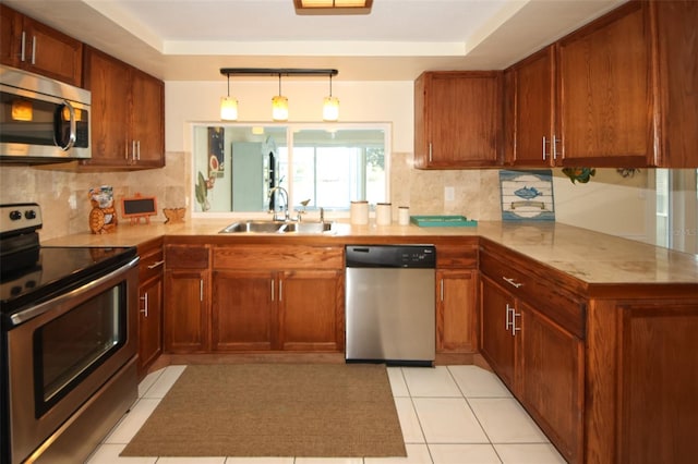 kitchen featuring appliances with stainless steel finishes, kitchen peninsula, sink, and backsplash