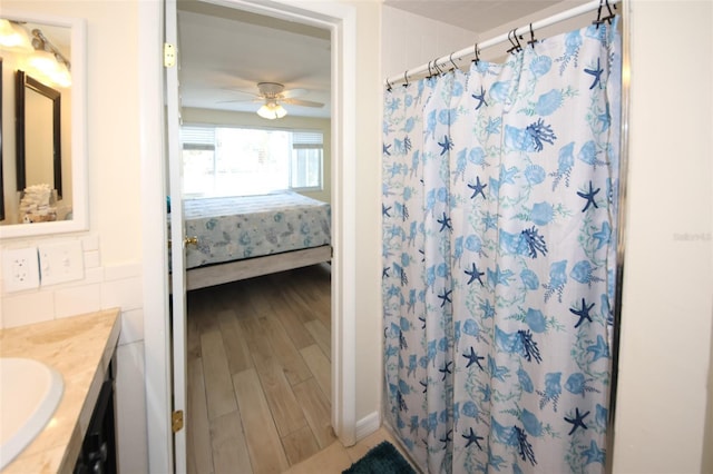 bathroom with vanity, curtained shower, wood-type flooring, and ceiling fan