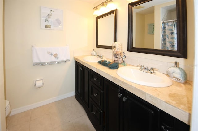 bathroom with tile patterned flooring, vanity, and toilet