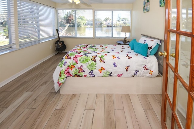 bedroom with hardwood / wood-style floors and multiple windows