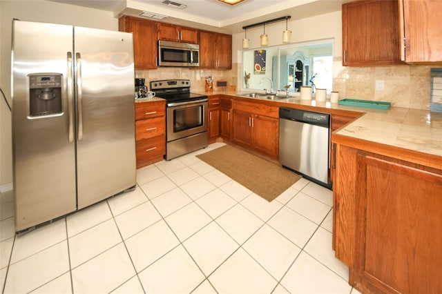 kitchen featuring tasteful backsplash, appliances with stainless steel finishes, sink, and light tile patterned floors