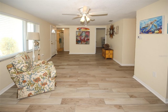 living area with ceiling fan and light wood-type flooring