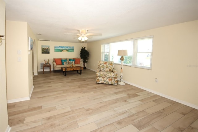 living area featuring light hardwood / wood-style flooring and ceiling fan