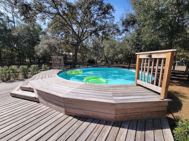 view of pool with a wooden deck and a jacuzzi