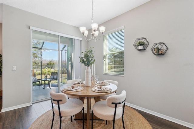 dining space featuring dark wood-type flooring and a chandelier