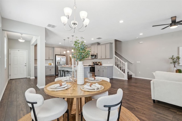 dining space featuring dark hardwood / wood-style floors and ceiling fan with notable chandelier