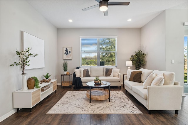 living room with dark wood-type flooring and ceiling fan