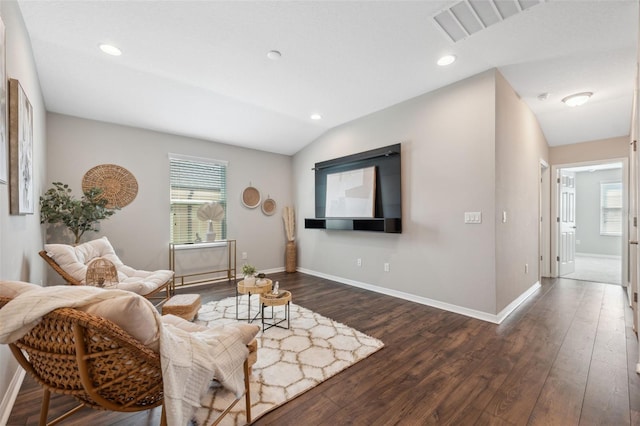 living room featuring lofted ceiling, dark hardwood / wood-style flooring, and a wealth of natural light