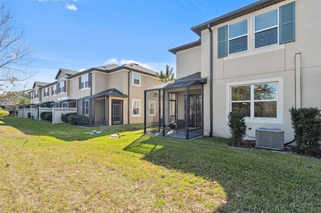 back of property with cooling unit, a lawn, and a sunroom