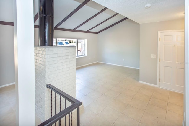 unfurnished room featuring lofted ceiling, a textured ceiling, and light tile patterned floors