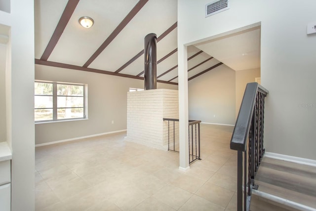 stairs with tile patterned floors and vaulted ceiling with beams