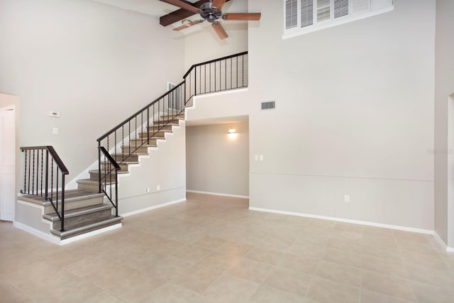 stairs featuring ceiling fan and a towering ceiling