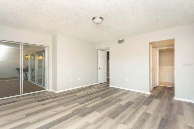 unfurnished room featuring hardwood / wood-style floors and a textured ceiling