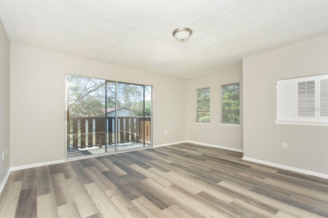 unfurnished room featuring wood-type flooring and a textured ceiling