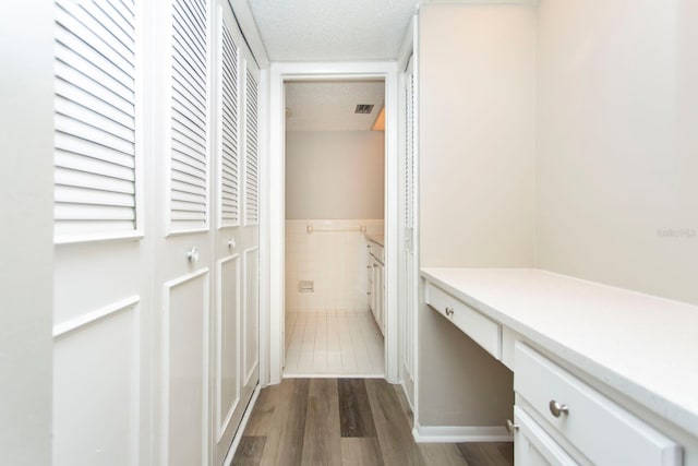 interior space with tile walls, hardwood / wood-style flooring, and a textured ceiling