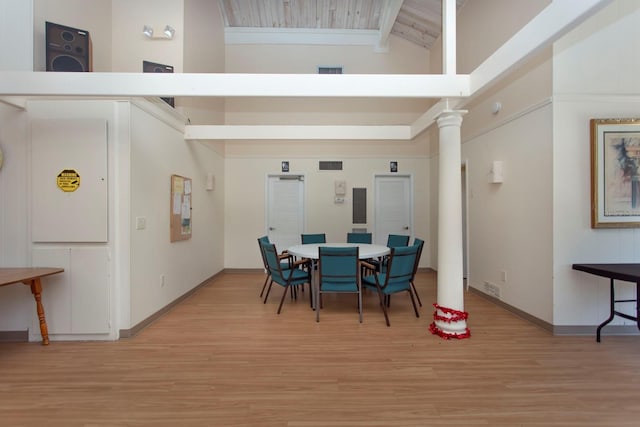 dining space featuring beamed ceiling, high vaulted ceiling, light hardwood / wood-style floors, and decorative columns