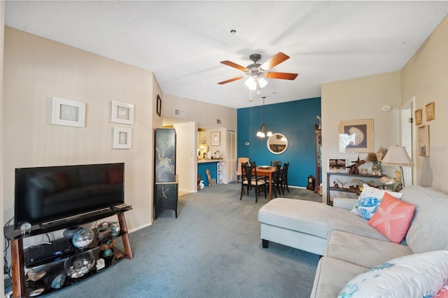 living room featuring carpet flooring, a textured ceiling, and ceiling fan