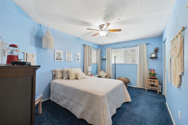 bedroom featuring ceiling fan, a textured ceiling, and dark carpet