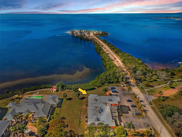 aerial view at dusk featuring a water view