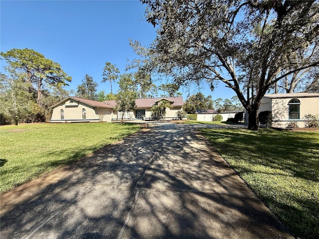 single story home featuring a front lawn and aphalt driveway