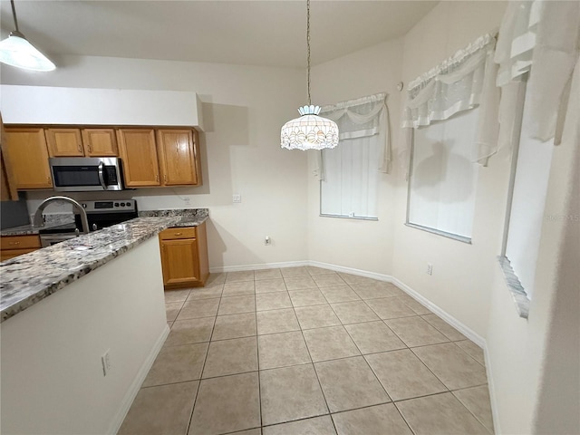 kitchen featuring light tile patterned floors, decorative light fixtures, and stainless steel appliances