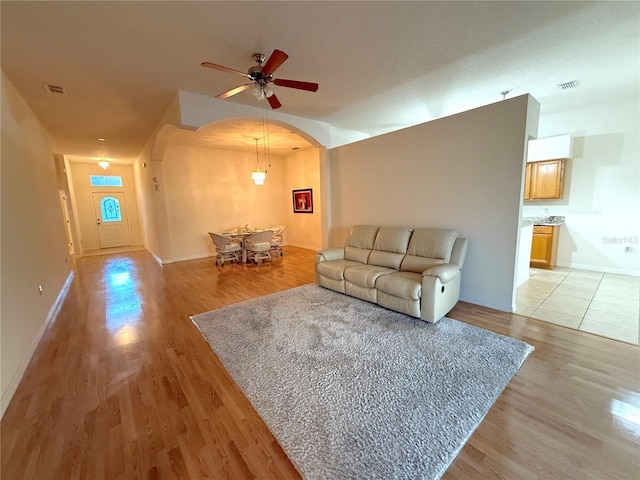 living room with ceiling fan and light wood-type flooring