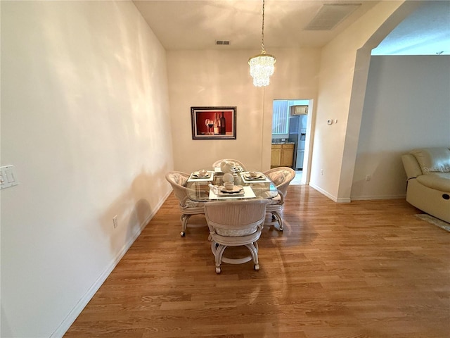 dining room with wood-type flooring and a chandelier