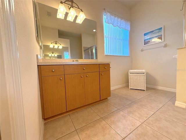 bathroom with tile patterned flooring, vanity, and walk in shower