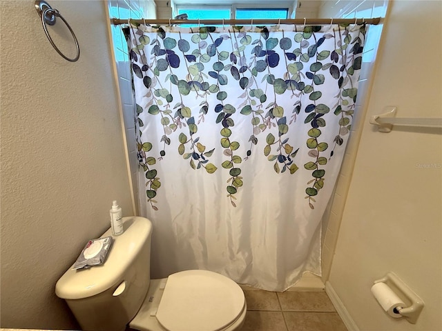 bathroom with tile patterned flooring, a shower with curtain, and toilet