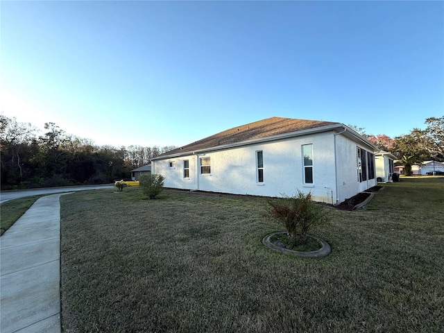 view of side of home with a yard