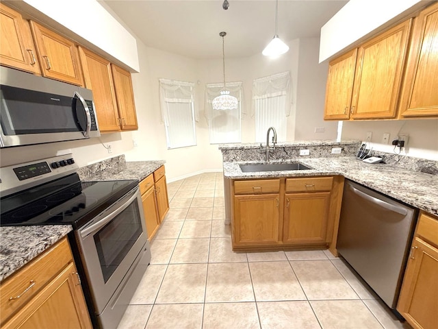 11204 Clear Oak Cir, New Port Richey, FL 34654 - kitchen featuring appliances with stainless steel finishes, a sink, a peninsula, light tile patterned flooring, and light stone counters