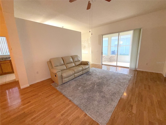 11204 Clear Oak Cir, New Port Richey, FL 34654 - unfurnished living room with light wood-style flooring, baseboards, and a ceiling fan