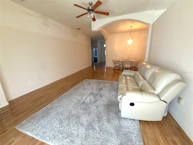 11204 Clear Oak Cir, New Port Richey, FL 34654 - living room with arched walkways, ceiling fan, and wood finished floors