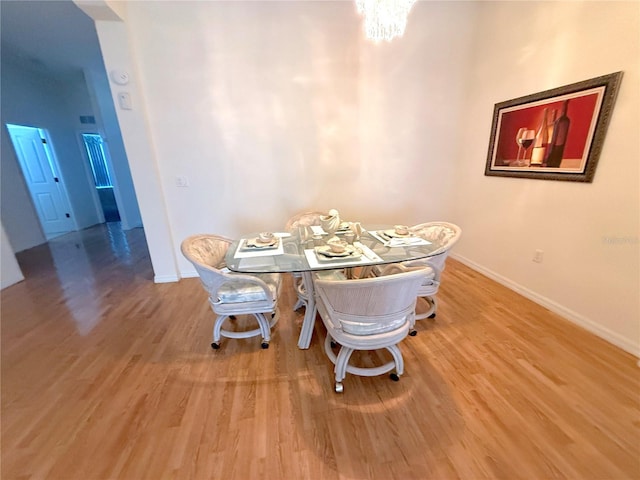 11204 Clear Oak Cir, New Port Richey, FL 34654 - dining room with light wood-style flooring, baseboards, and a chandelier