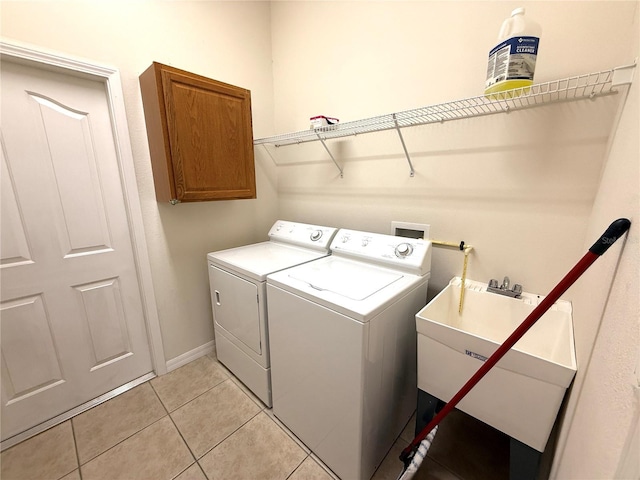 11204 Clear Oak Cir, New Port Richey, FL 34654 - washroom featuring independent washer and dryer, cabinet space, light tile patterned floors, and baseboards