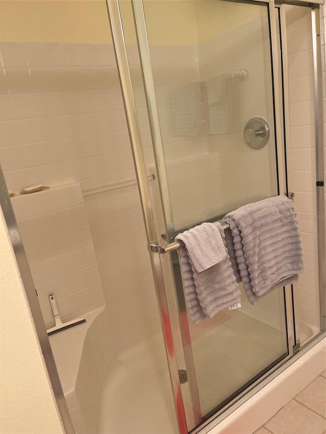 bathroom with tile patterned floors and a shower with door