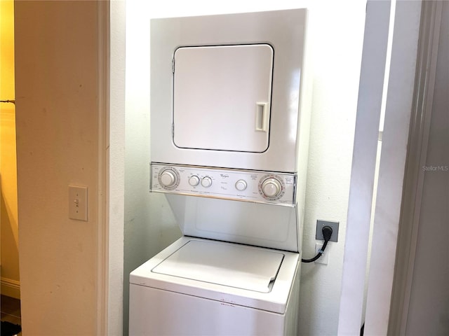 washroom featuring stacked washer and clothes dryer